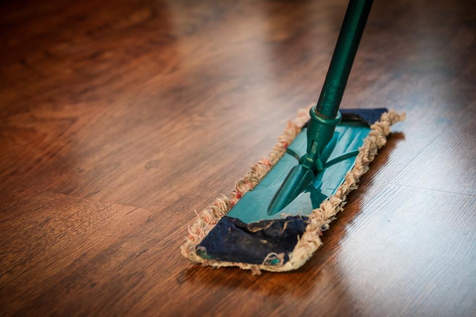 Wischmopp bei der Bodenreinigung auf einem Holzboden