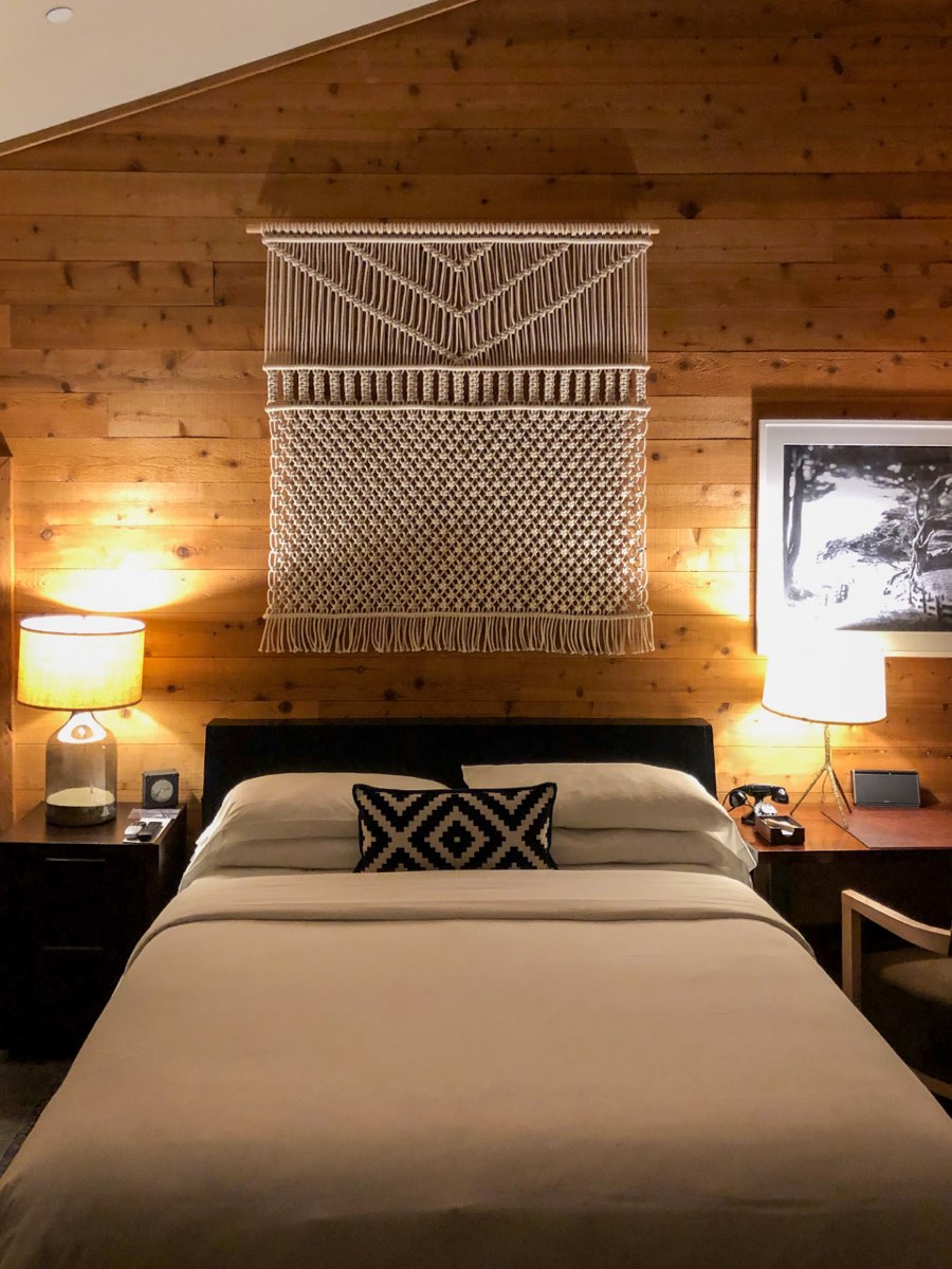 Gemütliches Schlafzimmer mit Holzwand und Nachttischlampen